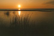 Auringonlasku kalajoen hiekkarannalla