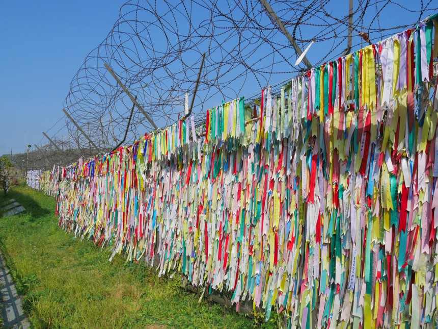 Kävijöiden kiinnittämiä rukousnauhoja Etelä-Korean puolella rajaa. Kuva: © Araya Gerabun | Dreamstime.com